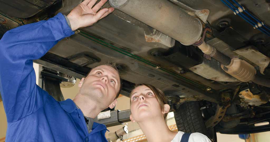Technician with customer looking at exhaust